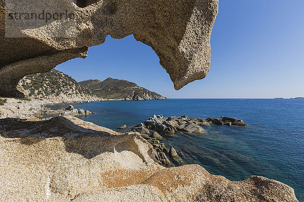 Blick auf das blaue Meer von einer natürlichen Meereshöhle aus vom Wind geformten Felsen  Punta Molentis  Villasimius  Cagliari  Sardinien  Italien  Mittelmeer  Europa