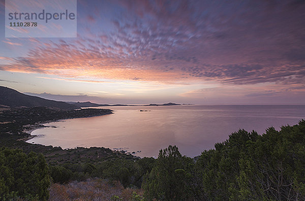 Die Farben des Sonnenaufgangs spiegeln sich auf dem Meer um den Strand von Solanas  Villasimius  Cagliari  Sardinien  Italien  Mittelmeer  Europa