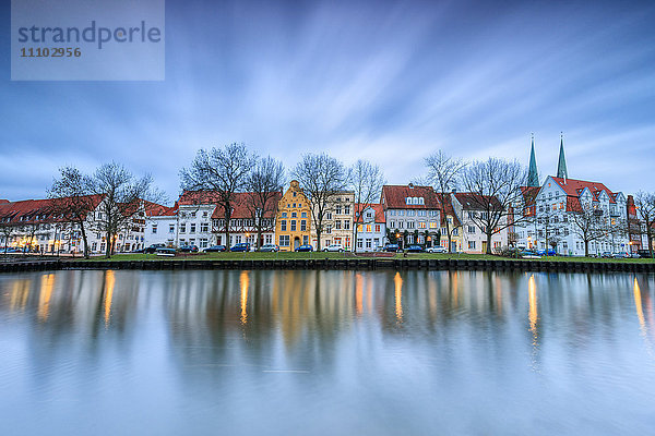 Wolken auf den typischen Häusern und Türmen des Doms spiegeln sich in der Trave in der Abenddämmerung  Lübeck  Schleswig Holstein  Deutschland  Europa