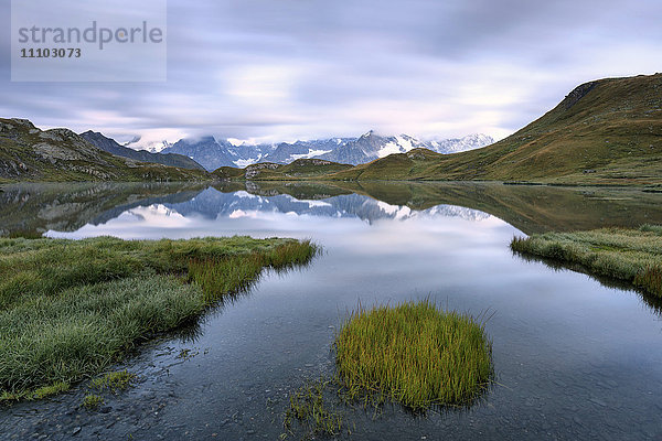 Die Bergkette spiegelt sich in der Abenddämmerung in den Fenetre Seen  Ferrettal  Saint Rhemy  Großer Sankt Bernhard  Aostatal  Italien  Europa