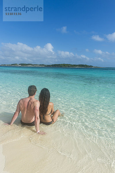 Paar an einem weißen Sandstrand im türkisfarbenen Wasser der Exumas  Bahamas  Westindische Inseln  Karibik  Mittelamerika