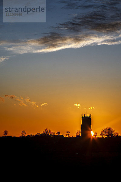 Sonnenuntergang hinter der Parish Church of the Holy Trinity and All Saints in Winterton on Sea  Norfolk  England  Vereinigtes Königreich  Europa