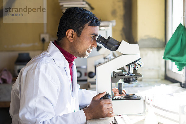 Ein Laborant  der in einem Labor in einem kleinen Krankenhaus in Nepal arbeitet  schaut in ein Mikroskop  Jiri  Solu Khumbu  Nepal  Asien