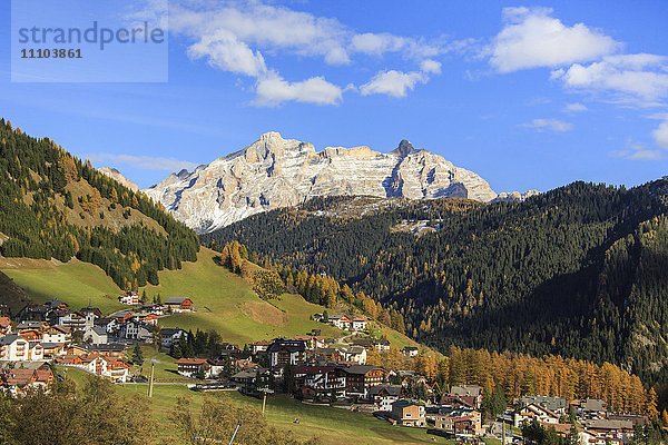 Bunte Wälder umrahmen das Dorf und die hohen Gipfel im Herbst  Grödnerjoch  Südtirol  Trentino-Südtirol  Italien  Europa