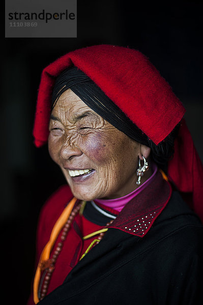 Eine chinesische Ngawa-Frau trägt ein traditionell helles Kleid in Songpa  Sichuan  China  Asien