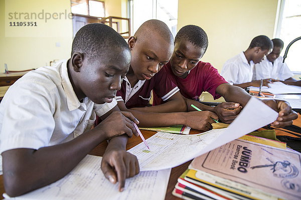 Kinder lernen während einer Unterrichtsstunde mit dem VSO-Freiwilligen Paul Jennings und der einheimischen Lehrerin Rebecca Ngovano in der Angaza-Schule  Lindi  Tansania  Ostafrika  Afrika