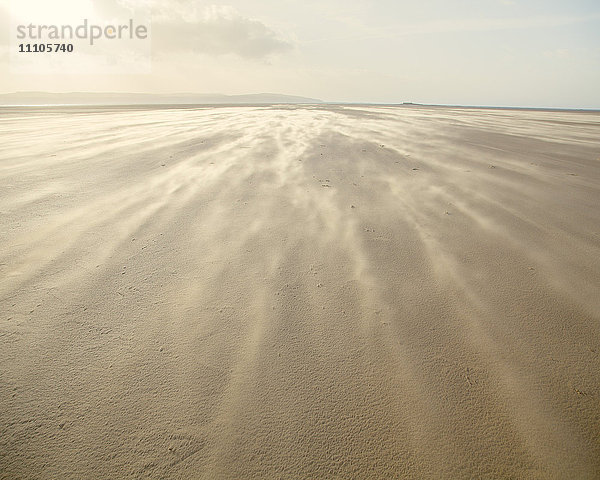Der sich bewegende Sand erzeugt eine Wolke unter den Füßen  während der Wind über den Strand pfeift  West Kirkby  Wirral  England  Vereinigtes Königreich  Europa