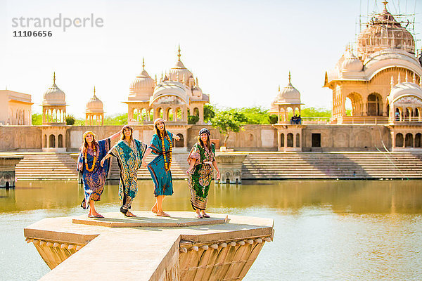 Weibliche Touristen stehen während des Holi-Festivals vor einem Tempel  Vrindavan  Uttar Pradesh  Indien  Asien