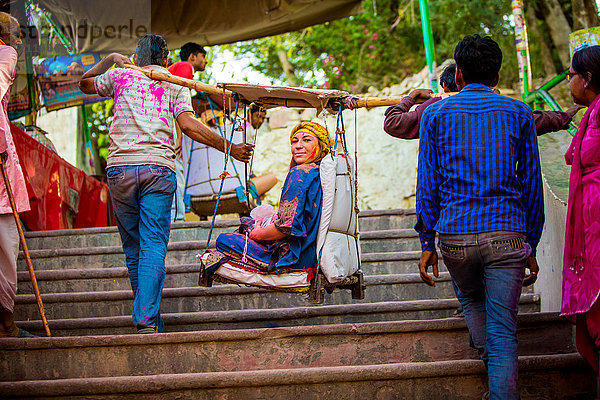 Frau  die in einem Hängesessel zum Tempel getragen wird  Holi Festival  Vrindavan  Uttar Pradesh  Indien  Asien