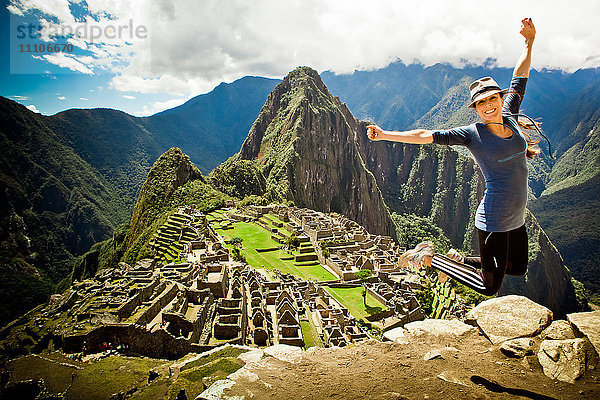 Laura Grier springt in den Ruinen von Machu Picchu  Peru  Südamerika