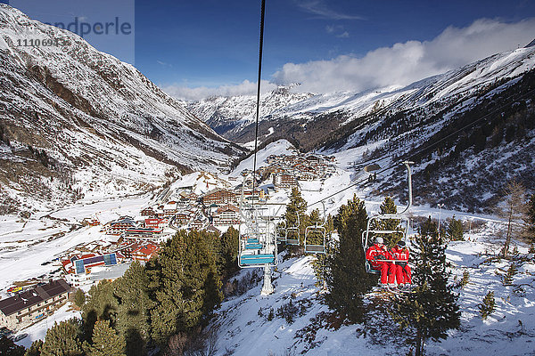 Blick auf das Dorf Obergurgl am oberen Ende des Otztals  während Skifahrer mit Sesselliften den Berg hinauffahren  Tirol  Österreichische Alpen  Österreich  Europa