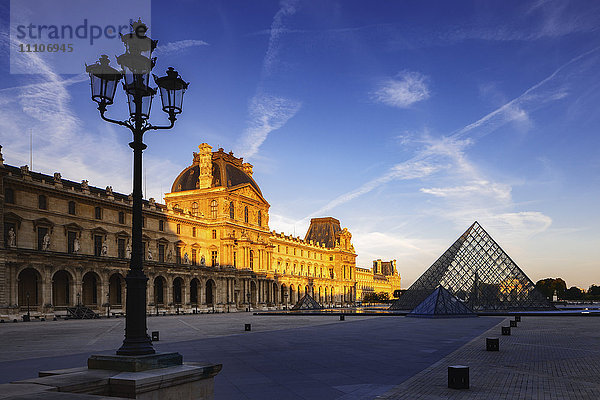 Das Licht der Morgendämmerung beleuchtet den Louvre-Palast am Rande des Napoleon-Hofs und der Louvre-Pyramide  Paris  Frankreich  Europa