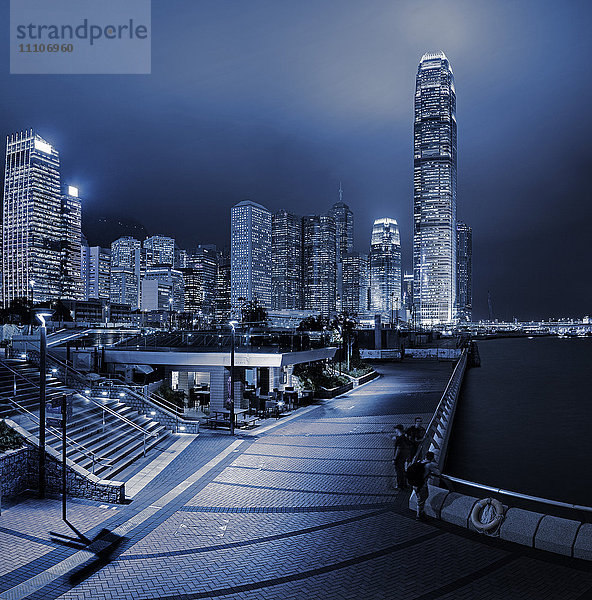 Die Promenade des Central und Western District führt zu den Wolkenkratzern auf der Insel Hongkong über dem Victoria Harbour bei Nacht  Hongkong  China  Asien