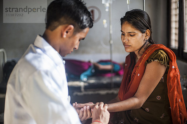 Ein Arzt misst den Pulsdruck einer Frau in einem Krankenhaus in Nepal  Asien