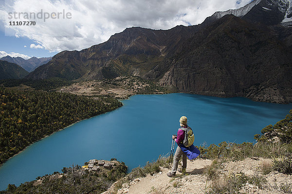 Ein Trekker steht über dem türkisblauen Phoksundo-See in der Dolpa-Region  Himalaya  Nepal  Asien