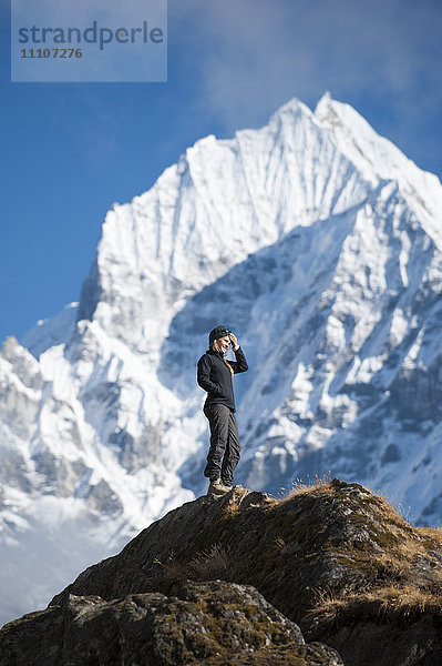 Ein Trekker genießt die Aussicht über Namche in der Everest-Region mit Blick auf den Thermserku in der Ferne  Himalaya  Nepal  Asien