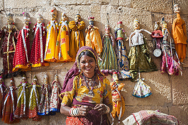 Eine Frau verkauft Puppen entlang der Festungsmauern in Jaisalmer im Wüstenstaat Rajasthan  Indien  Asien