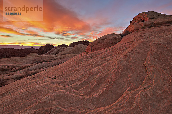 Leuchtend orange Wolken bei Sonnenaufgang über Sandstein  Valley Of Fire State Park  Nevada  Vereinigte Staaten von Amerika  Nordamerika