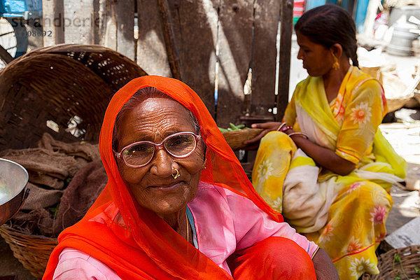 Zwei Frauen in traditioneller Kleidung auf einem Straßenmarkt in der Stadt Udaipur  Rajasthan  Indien  Asien