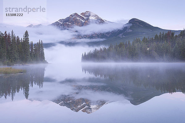 Ein nebliger Pyramid Mountain spiegelt sich im Pyramid Lake in der Morgendämmerung  Jasper National Park  Kanadische Rockies  UNESCO-Weltkulturerbe  Alberta  Kanada  Nordamerika