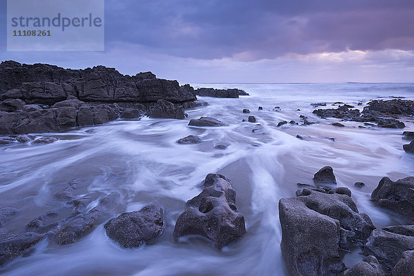 Sonnenuntergang vor der zerklüfteten Küste von Porthcawl an der Küste von Glamorgan im Winter  Wales  Vereinigtes Königreich  Europa