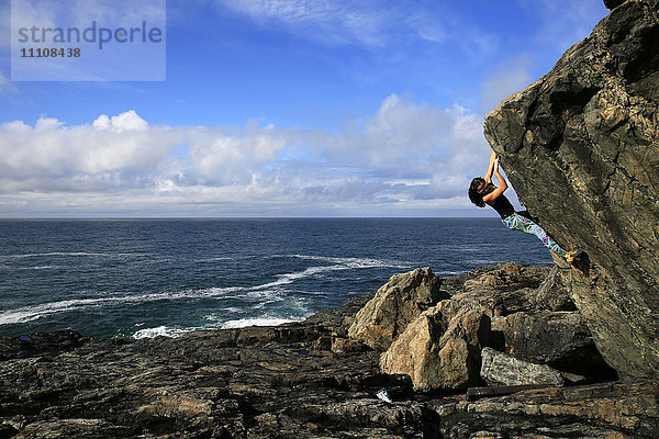 Ein Kletterer beim Bouldern am Meer in der Nähe von St. Ives  Cornwall  England  Vereinigtes Königreich  Europa