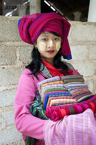 Junges Mädchen mit Thanaka-Paste im Gesicht  das Schals und Sarongs im Nyaung Oak-Kloster  Indein  Inle-See  Shan-Staat  Myanmar (Burma)  Asien  verkauft