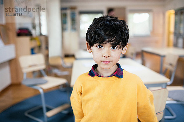 Porträt eines Jungen  der im Klassenzimmer steht