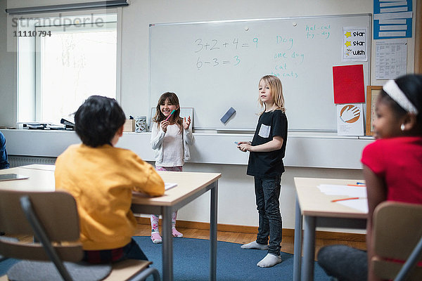 Schüler erklären den Klassenkameraden im Klassenzimmer