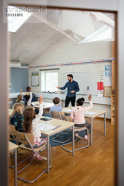 Lehrer bittet die Schüler vom Eingang des Klassenzimmers aus zu sehen.