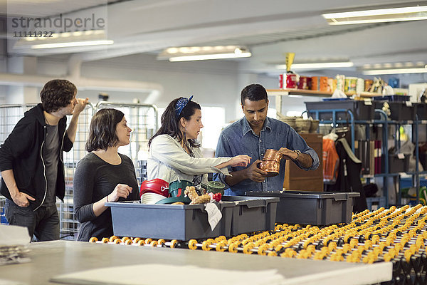 Freiwillige bei der Analyse von Objekten in Kisten auf der Produktionslinie in der Werkstatt