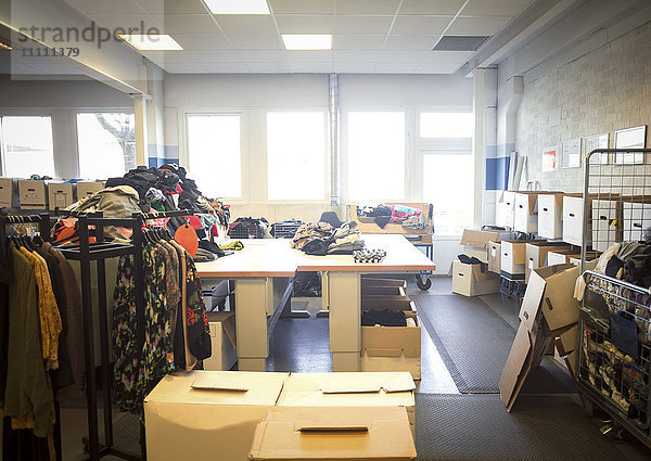 Diverse Kleidungsstücke und Gegenstände mit Boxen in der hell erleuchteten Werkstatt