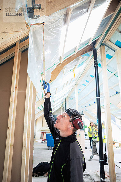 Seitenansicht des Schreiners beim Arbeiten auf der Baustelle