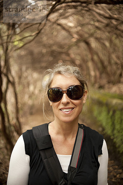 Kaukasische Frau mit Sonnenbrille im Freien stehend