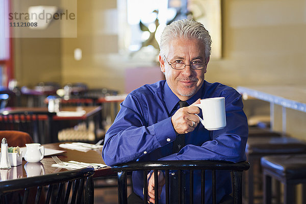 Hispanischer Kaffeehausbesitzer bei einer Tasse Kaffee