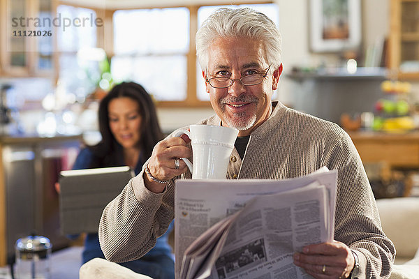 Hispanischer Mann trinkt Kaffee und liest Zeitung