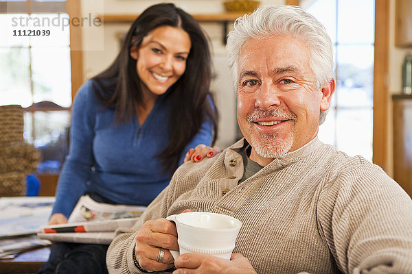 Hispanisches Paar lächelnd im Wohnzimmer