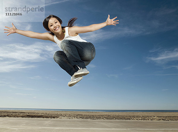 Asiatische Frau springt in die Luft