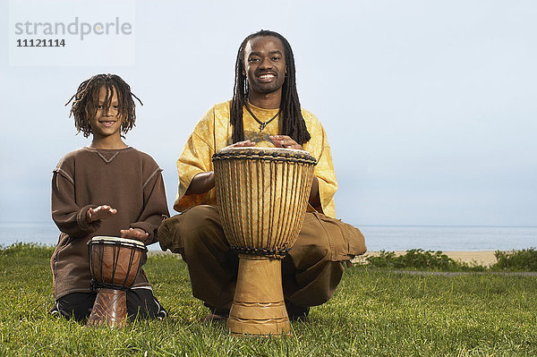 Afrikanischer Vater und Sohn beim Trommeln