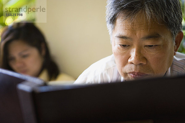 Reifer asiatischer Mann liest Buch
