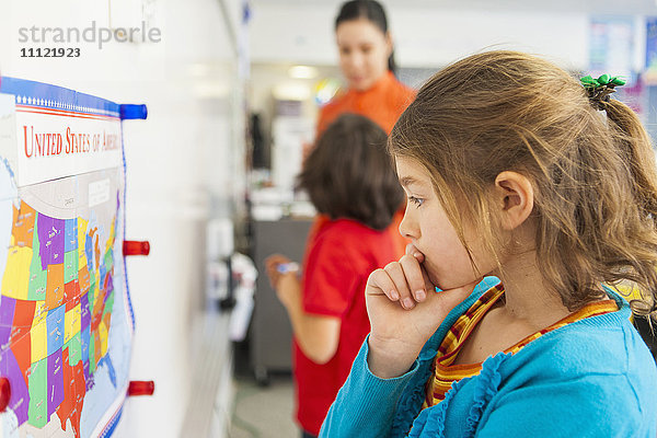 Kaukasischer Schüler liest Karte im Klassenzimmer