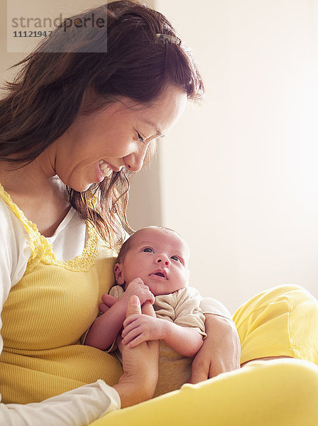 Mutter hält neugeborenes Baby in ihrem Schoß