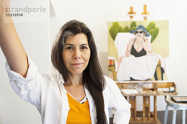 Hispanischer Künstler lächelt im Atelier