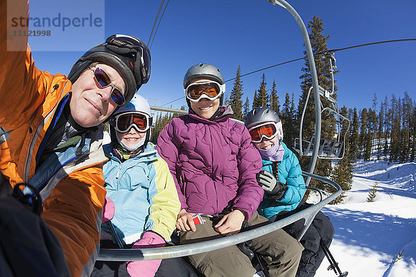 Familie fährt gemeinsam Skilift