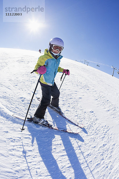 Gemischtrassiges Mädchen beim Skifahren bergab