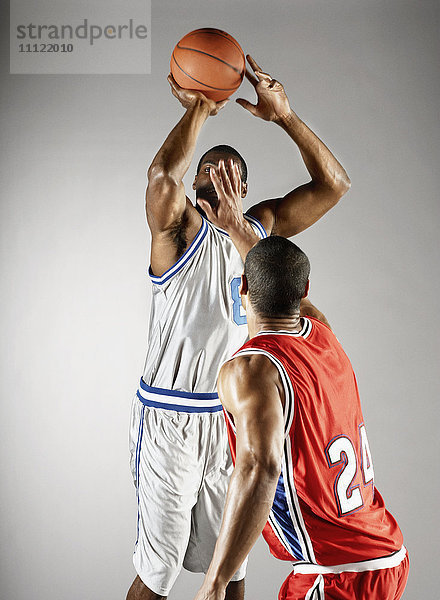 Basketballspieler versucht  dem Gegner den Basketball abzunehmen