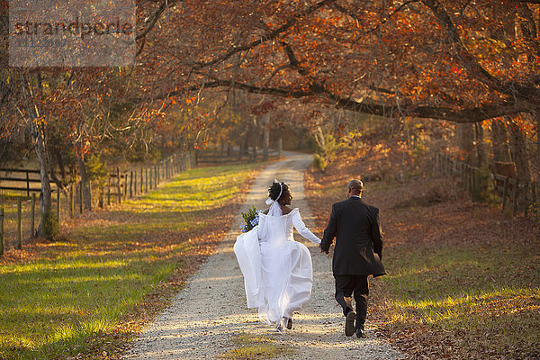 Braut und Bräutigam gehen auf einem Weg