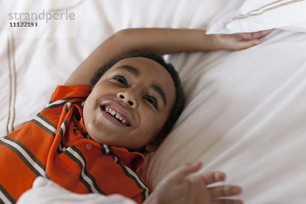 Gemischtrassiger Junge liegt im Bett