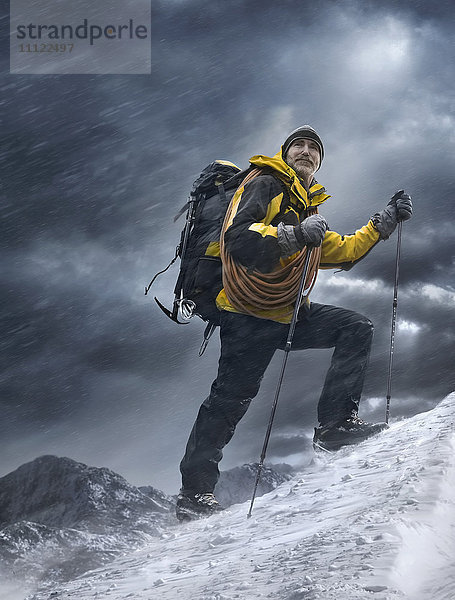 Kaukasischer Mann klettert auf verschneiten Berg