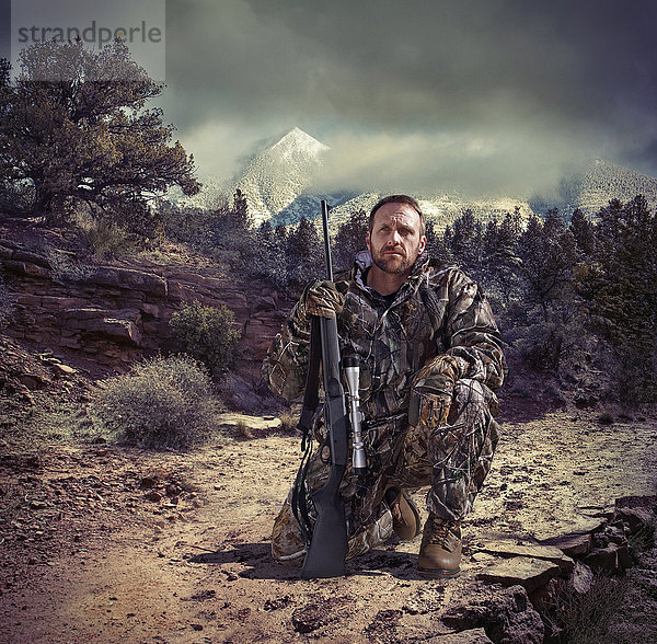 Soldat mit Gewehr in trockener ländlicher Landschaft